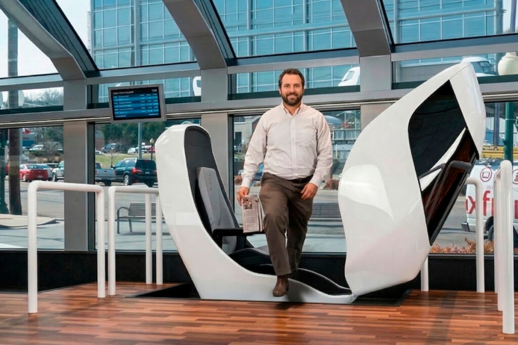 A rider stepping into a SNAAP pod prototype at a boarding platform